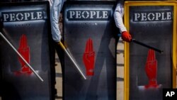 FILE - Anti-coup demonstrators hold makeshift shields during a protest in Yangon, Myanmar, March 9, 2021.