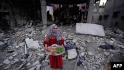 Палестинка се подготвува да послужи оброк среде урнатините на куќата на нејзиното семејство, на првиот ден од светиот муслимански месец Рамазан, на 11 март, 2024 година