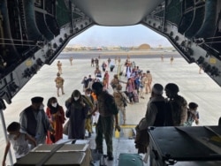 En esta foto proporcionada por el Ministerio de Defensa español y tomada en Kabul, Afganistán, personas a bordo de un avión A400 de la fuerza aérea española como parte de un plan de evacuación en el aeropuerto de Kabul, el 18 de agosto de 2021.