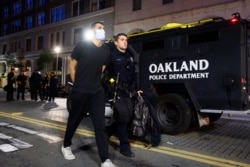 A police officer detains a demonstrator in Oakland, Calif., on June 1, 2020, during a rally for George Floyd, who died in the custody of Minneapolis police on May 25.