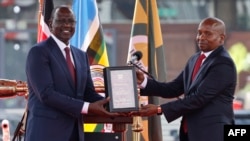 Rais wa Kenya William Ruto (Kushote) amkabidhi nakala ya katiba naibu wake mpya Kithure Kindiki muda mfupi baada ya kuapishwa nje ya jumba la KICC mjini Nairobi. Novemba 1, 2024.