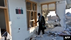 FILE - Afghan security forces arrive at the site of a car bomb attack that targeted a security outpost in Khogyani district of Nangarhar province, Feb. 7, 2021.