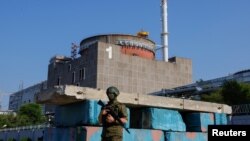 FILE - A Russian service member stands guard at a checkpoint near the Zaporizhzhia nuclear power plant outside Enerhodar in the Zaporizhzhia region, Russian-controlled Ukraine, June 15, 2023. 