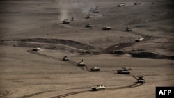 A convoy of tanks and armoured vehicles of the Iraqi army's 34th brigade advances near Talul al-Atshana, on the southwestern outskirts of Mosul, on Feb. 27, 2017, during an offensive to retake the city from Islamic State (IS) group fighters. 