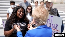 Rep. Cori Bush, D-Mo., left, greets Sen. Elizabeth Warren, D-Mass., after Warren arrived to support Bush, who spent the night at the U.S. Capitol to highlight the coming expiration of a pandemic-related federal moratorium on evictions, July 31, 2021.
