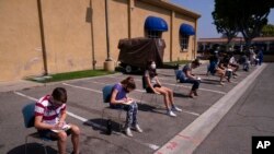 FILE - Children ages 12 to 15 wait to get their vitals checked before getting their Pfizer COVID-19 vaccine at Families Together of Orange County in Tustin, Calif., May 13, 2021. 