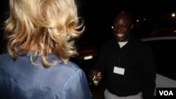 A woman (left) hands her car keys to Scooter Angels driver Blessing Mhango. Growing numbers of South Africans are using services such as his, Tuesday, Sept. 17, 2015. (photo: D. Taylor)