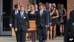 FILE - The casket of Otto Warmbier is carried from Wyoming High School after his funeral, June 22, 2017.
