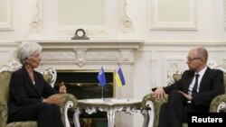 FILE - International Monetary Fund (IMF) Managing Director Christine Lagarde speaks with Ukraine's Prime Minister Arseny Yatseniuk during their meeting in Kiyv, Ukraine, Sept. 6, 2015.