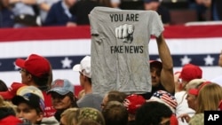 ARSIP – Foto arsip yang diambil tanggal 4 Oktober 2018, menunjukkan pendukung Trump yang mengangkat sehelai T-shirt dengan tulisan “You Are Fake News” sebelum pawai akbar yang dihadiri Presiden Donald Trump di Rochester, Minn (foto: AP Photo/Jim Mone, Arsip)