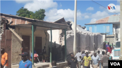 Grupos de haitianos observan los destrozos causados por un fuerte terremoto de magnitud 7,0 en el oriente del país el 14 de agosto de 2021. Foto de Makenson Charles, VOA.