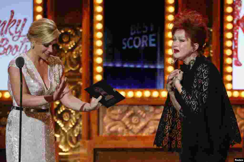 Cyndi Lauper enters the stage to accept the award for Best Original Score (Music and/or Lyrics) Written for the Theatre for "Kinky Boots" from Jane Krakowski during the Tony Awards in New York, June 9, 2013.