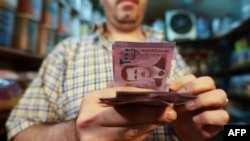 A merchant counts Syrian pound notes at the Bzourieh market in the center of the Syrian capital Damascus, Sept. 11, 2019.