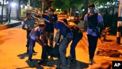 Người d&#226;n gi&#250;p đỡ nạn nh&#226;n bị thương sau vụ tấn c&#244;ng của những phần tử hiếu chiến tại một nh&#224; h&#224;ng ở thủ đ&#244; Dhaka.