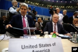 U.S. Secretary of State John Kerry, left, takes his seat to participate in the Organization for Security and Cooperation in Europe (OSCE) ministerial council meeting in Belgrade, Serbia Thursday, Dec. 3, 2015.