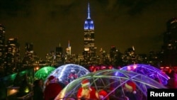 The Empire State Building is seen in the background as revelers take part in the annual SantaCon event in Manhattan, New York, Dec. 10, 2016. 