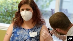 Shylah Hallam-Noel, a worker at Queen Anne Healthcare, a skilled nursing and rehabilitation facility in Seattle, Washington, gets the second shot of the Pfizer vaccination for COVID-19, Jan. 8, 2021.