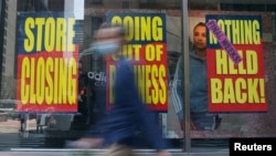 People walk past a business that is closing following the outbreak of COVID-19 in the Manhattan borough, New York, Aug. 17, 2020.