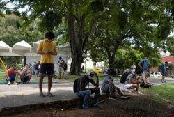 People gather in Martyrs Park where wifi connections are working in Havana, Cuba, July 13, 2021. Cuban President Miguel Díaz-Canel is accusing Cuban Americans of using social media to spur Sunday's nationwide antigovernment protests.