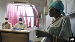 Pinky Molefe (R) gets TB medication at a clinic in Alexandra township north of Johannesburg, South Africa, Oct. 13, 2010 (file photo)