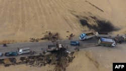 An areal picture taken on Oct. 28, 2019, shows vehicles near a destroyed truck at the spot where Abu Hassan al-Muhajir, the Islamic State (IS) group's spokesman, was reportedly killed in a raid in the Syrian village of Ayn al-Bayda near Jarablus.