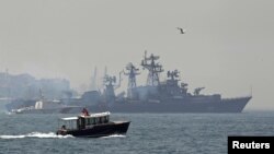 A Turkish Navy cost guard boat (L) escorts the Russian Navy destroyer Smetlivy, in the Bosphorus in Istanbul, July 11, 2012. 