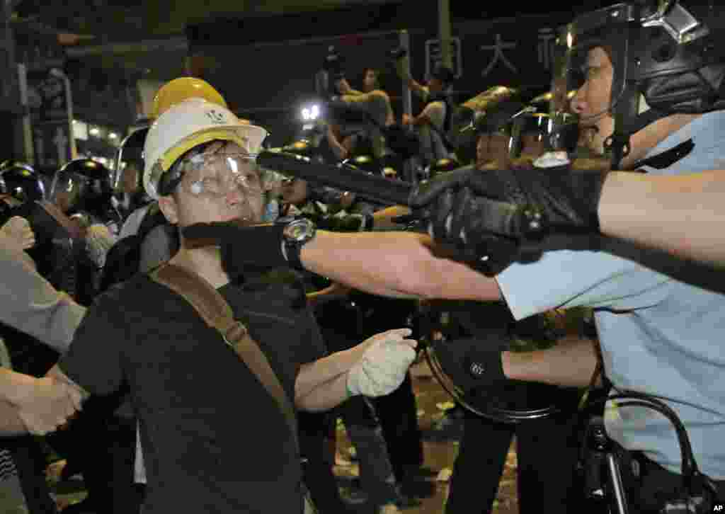 Police officers scuffle with protesters at an occupied area in the Mong Kok district of Hong Kong, Nov. 26, 2014.