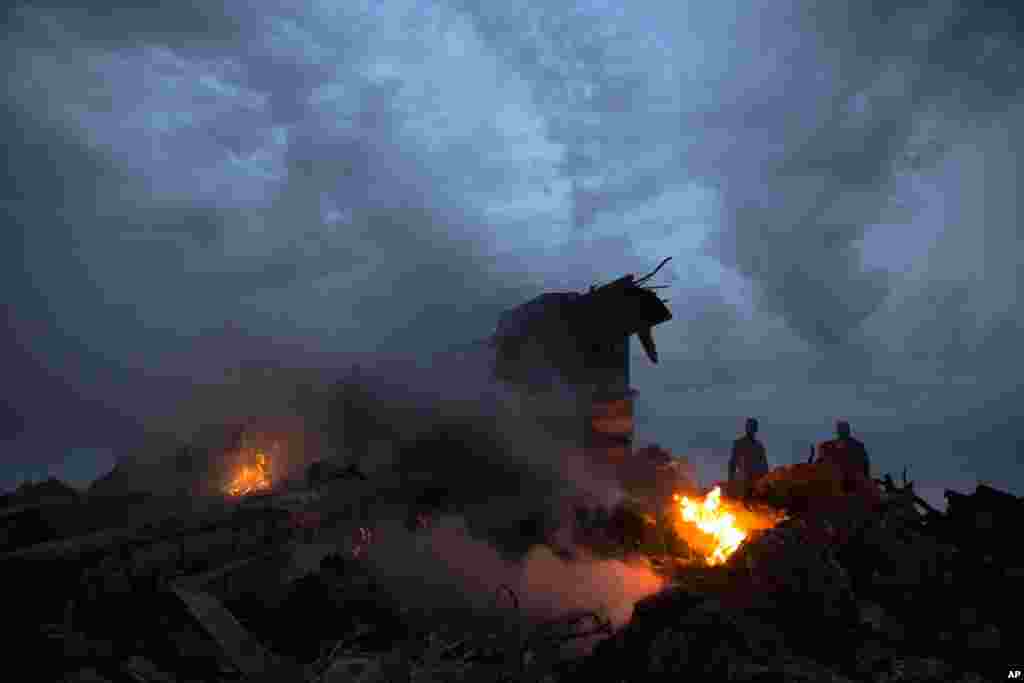 People walk amongst the debris at the crash site of a passenger plane near the village of Grabovo, Ukraine.