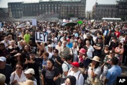 FILE - Thousands of people protest in Mexico City in opposition to President-elect Andres Manuel Lopez Obrador's plans to cancel a new $13 billion airport for the capital, Nov. 11, 2018.