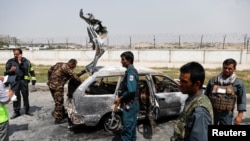 Afghan police officers inspect a vehicle from which insurgents fired rockets, in Kabul, Afghanistan, Aug. 18, 2020.
