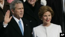 FILE - President Bush takes the oath of office with first lady Laura Bush at his side at the US Capitol in Washington, Jan. 20, 2005.