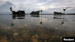 FILE - Decaying wrecks of confiscated foreign trawlers rot in a shallow estuary near Penagi on Natuna Besar.