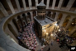 Roman Catholic clergymen carry palm fronds during the Palm Sunday procession at Church of the Holy Sepulchre, traditionally believed by many to be the site of the crucifixion and burial of Jesus Christ, in Jerusalem's Old City, March 29, 2015.