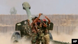 Fighters take a selfie while firing artillery against Islamic State militants in Fallujah, Iraq on Sunday, May 29, 2016.