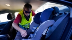 FILE - Dave, who declined to give his last name, from Ohio, installs a child seat in his vehicle as he waits for his friend Ruth, a Haitian migrant, and her family, who he believes are in U.S. Customs and Border Protection custody, Sept. 24, 2021, in Del Rio, Texas.