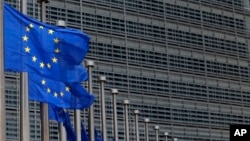 FILE - European Union flags set of half staff outside the European Commission headquarters in Brussels, Belgium.
