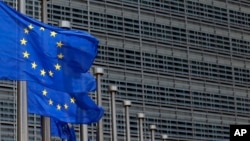 FILE - European Union flags set of half staff outside the European Commission headquarters in Brussels, Belgium.