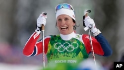 Norway's Marit Bjoergen celebrates winning the gold during the women's classical-style cross-country team sprint competitions at the 2014 Winter Olympics, Feb. 19, 2014, in Krasnaya Polyana, Russia.