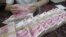 An employee counts Chinese 100 yuan banknotes at a branch of Bank of Communications in Shenyang, Liaoning province July 6, 2012.