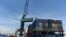 FILE - Containers are transferred from a truck to a cargo ship at the international cargo terminal of a port in Hai Phong, Vietnam, Aug. 12, 2019.