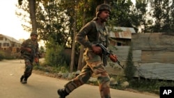 Indian army soldiers arrive at the site of a gunbattle in Pulwama, some 35 kilometers (22 miles) from Srinagar, Indian-controlled Kashmir, Aug. 6, 2015.