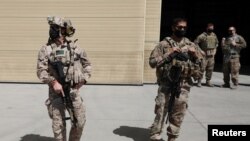 FILE - U.S. troops stand guard during a handover ceremony of A-29 Super Tucano planes from U.S. to Afghan forces, in Kabul, Sept. 17, 2020. 