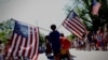 Момче носи американски знамиња низ селото Барнстејбл, Масачусетс, за време на годишната парада на четврти јули на која се прославува Денот на независноста на САД, 4 јули 2024 година.