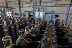 A worker refills oxygen cylinders in a factory, amidst the spread of the COVID-19 in Ahmedabad, India, Jan. 10, 2022.