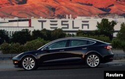 Model produksi Tesla Model 3 yang pertama yang keluar dari lini perakitan di Fremont, California