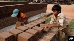 FILE - Cambodian children prepare bricks to dry under the sun at a brick factory in Chheuteal village, Kandal province, some 27 kilometers (17 miles) north of Phnom Penh, Cambodia, May 2, 2011.