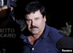 FILE - Recaptured drug lord Joaquin 'El Chapo' Guzman is escorted by soldiers at the hangar belonging to the office of the Attorney General in Mexico City, Mexico Jan. 8, 2016.