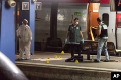 Police officers conduct their investigation on an Amsterdam-to-Paris train after a gunman wounded three people before being overpowered, at Arras station, northern France, Aug. 21, 2015.
