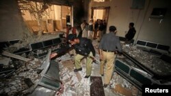 Petugas keamanan tengah memeriksa lokasi ledakan bom di Kompleks Pengadilan di Peshawar, Pakistan (18/3).