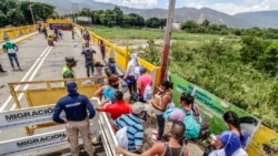 Venezuelans returning home have their documents checked by Colombian migration officials on the border between Colombia and Venezuela, on August 21, 2020.